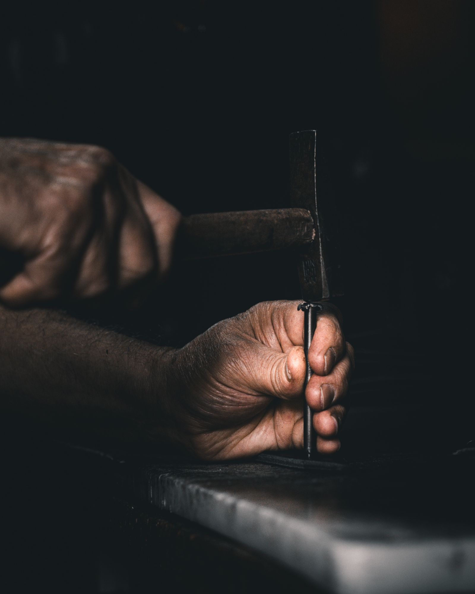 A roofer’s hands holding a fistful of roofing nails