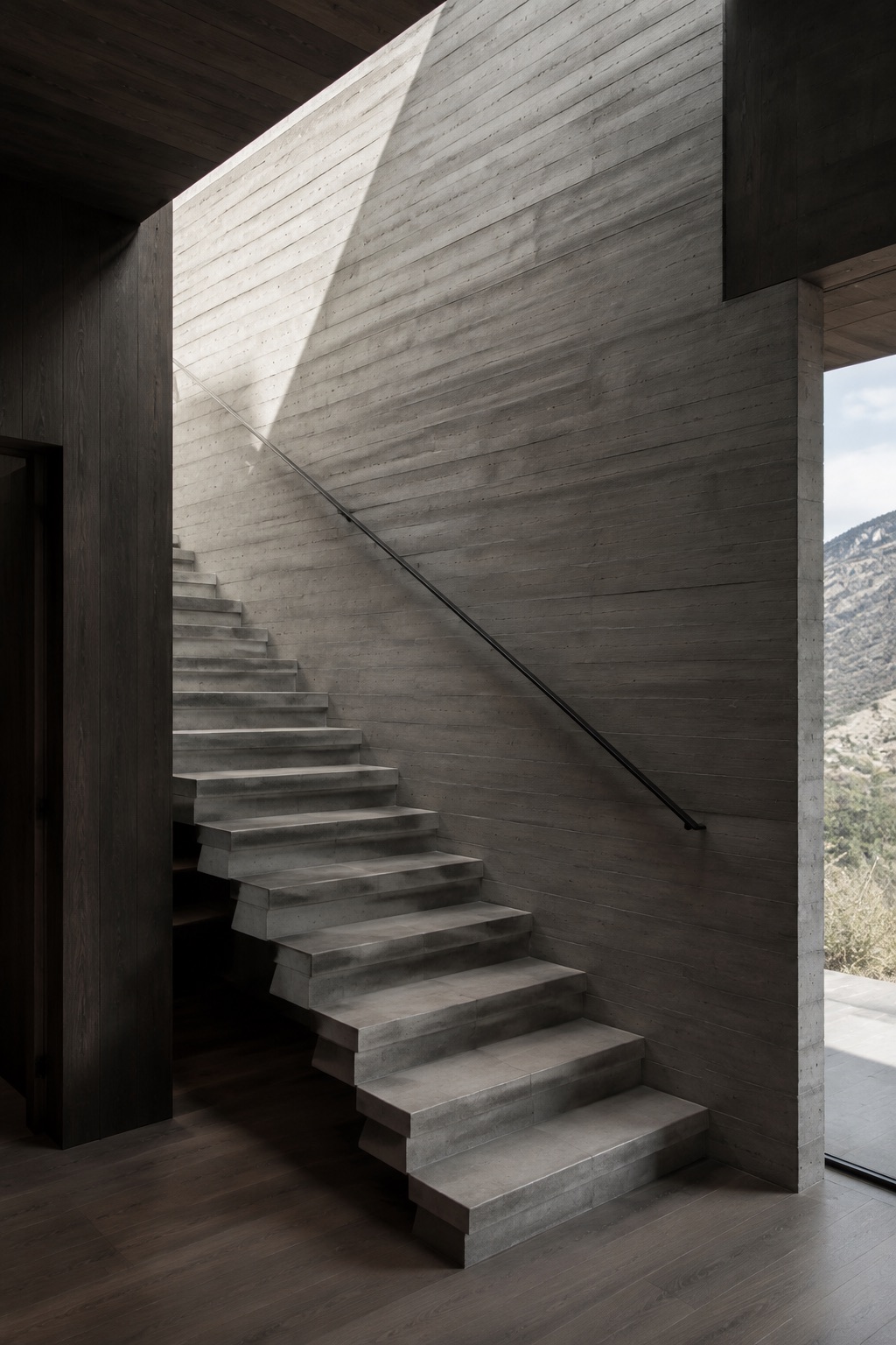 Daylight falling across a monolithic concrete stair at Ridgeline House.